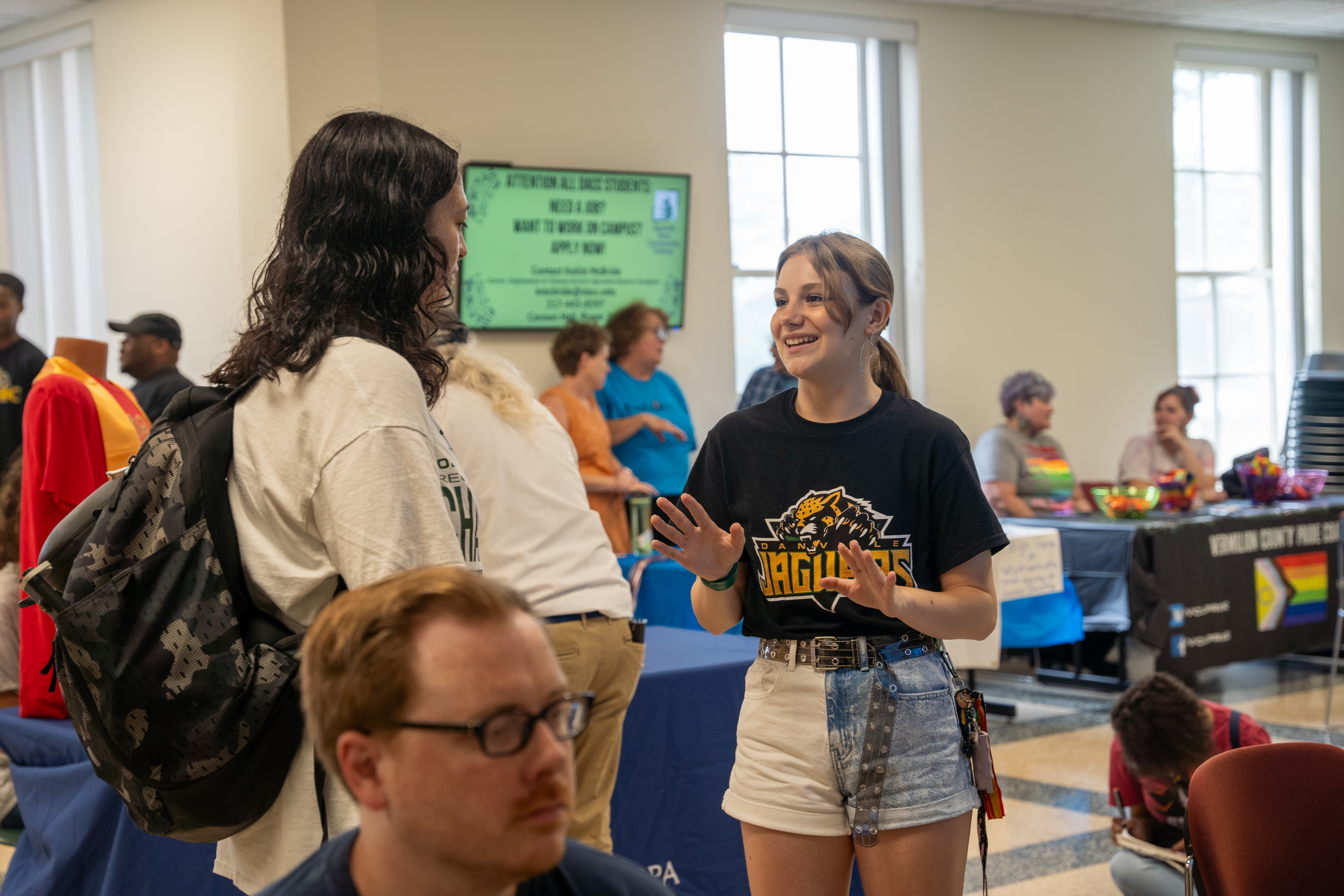 All Star Jaguar Member talking to a student at an event